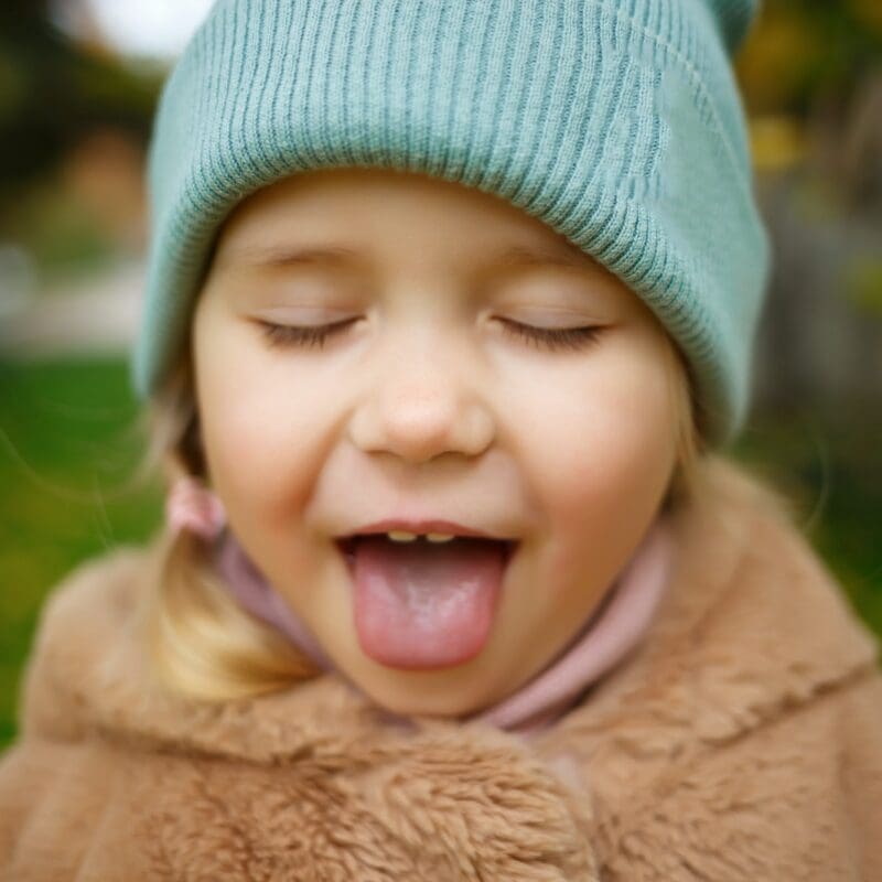 portrait of a little cute girl with sticking out tongue