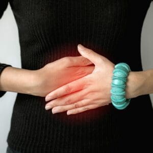 Woman hand holding on stomach suffering from abdominal pain