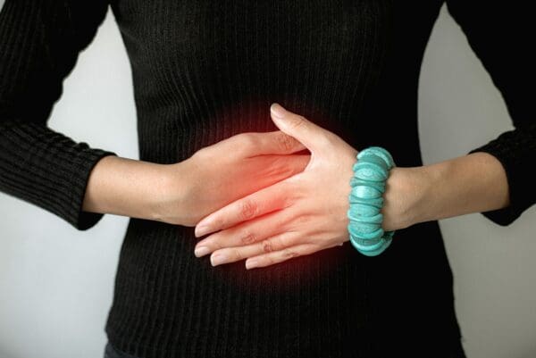 Woman hand holding on stomach suffering from abdominal pain